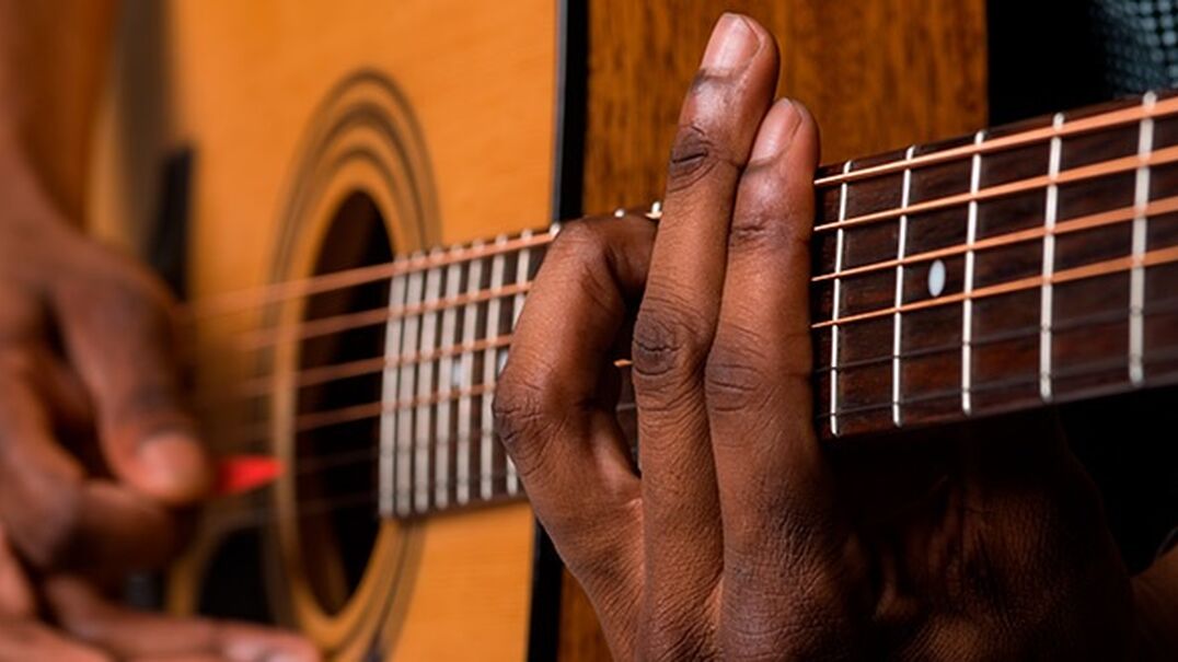Close up of boys hands playing guitar