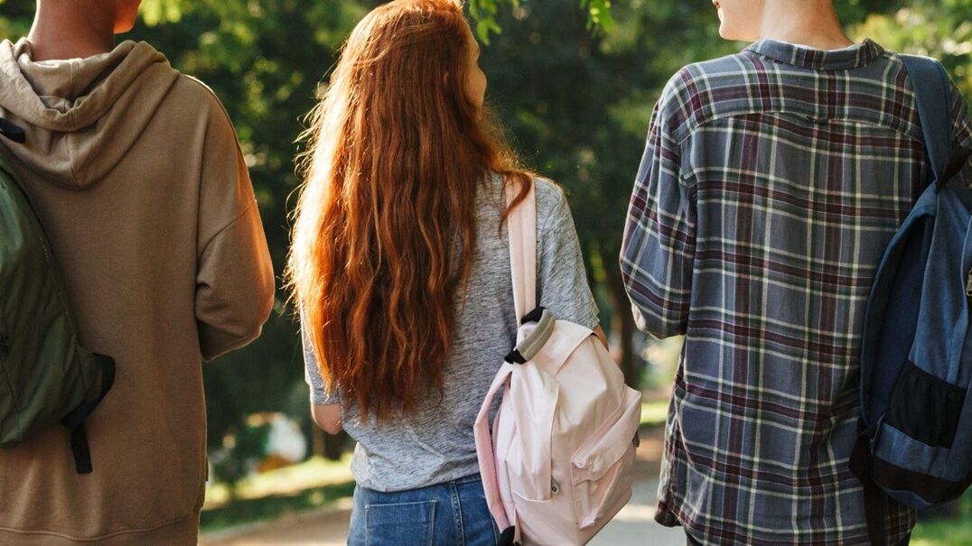 Three teenagers walking together in a park