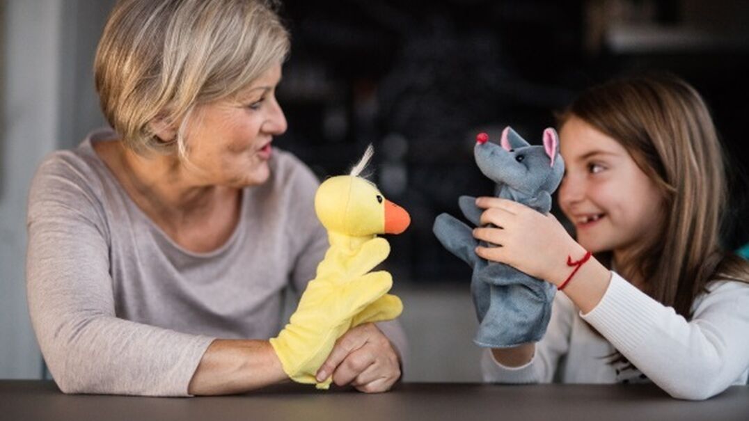 Adult and child playing with handheld puppets