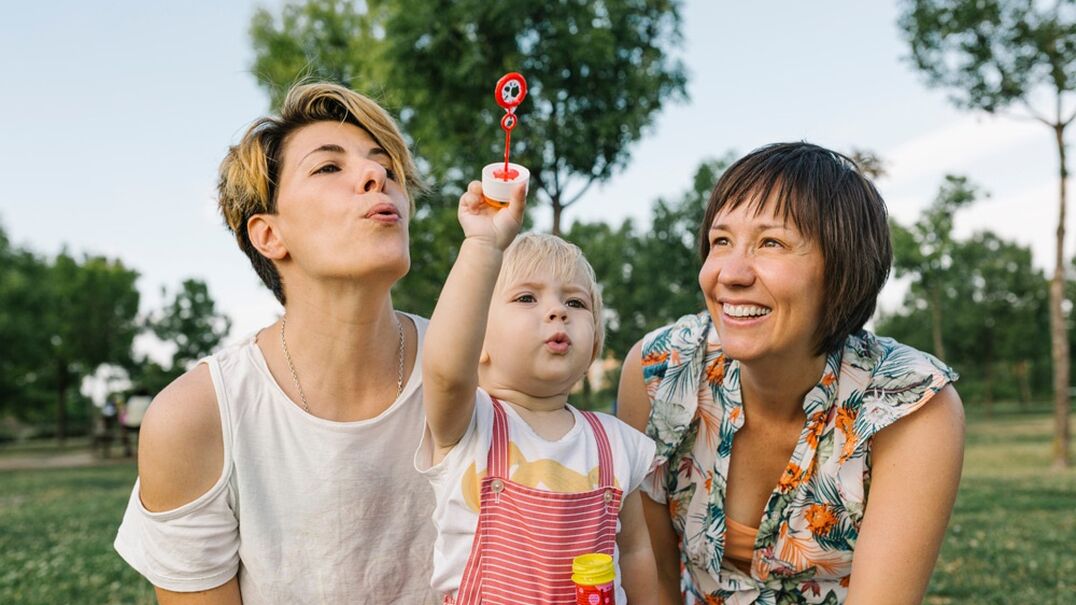 Two woman with child blowing bubbles
