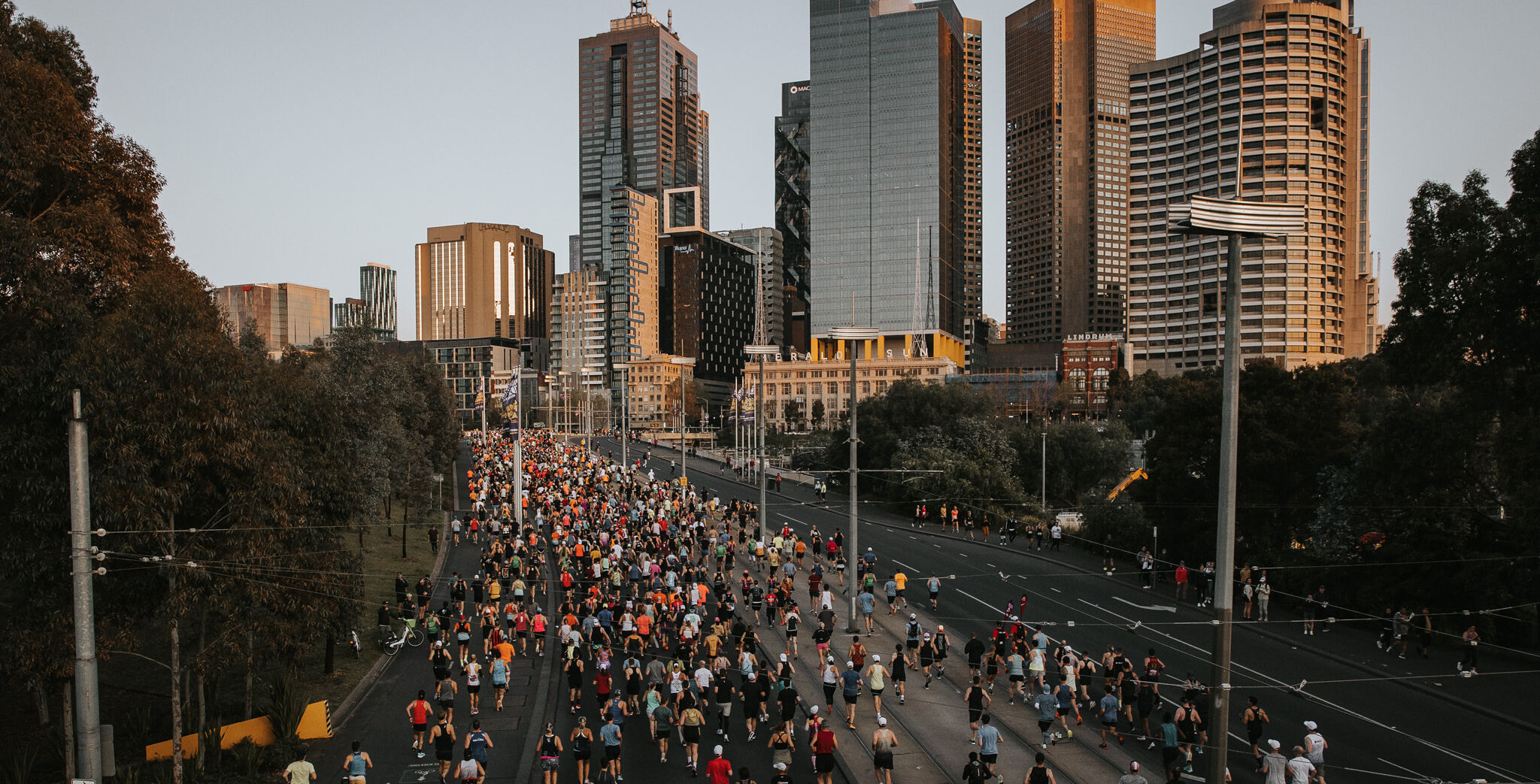 A large group of runners runs through the streets of Melbourne