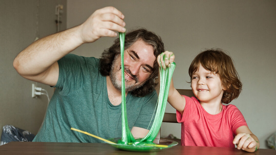 Little boy and caregiver playing with slime