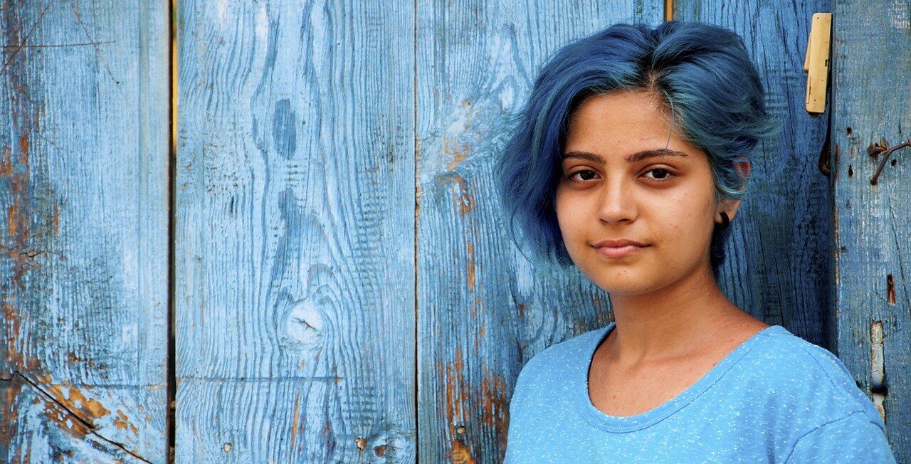 Girl with blue hair and neutral facial expression