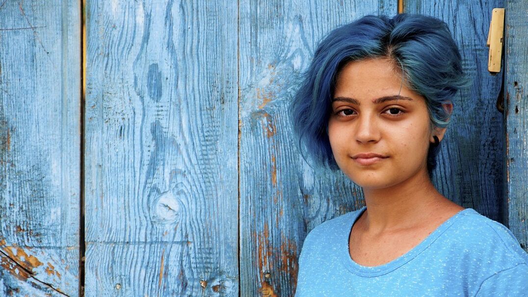 Girl with blue hair and neutral facial expression