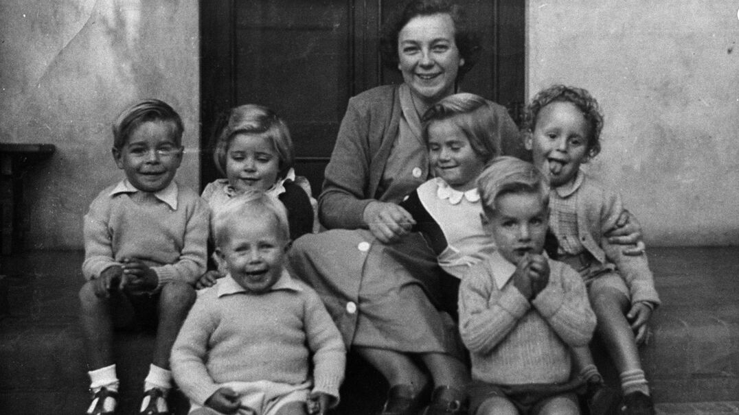 Historical image of lady sitting with six children