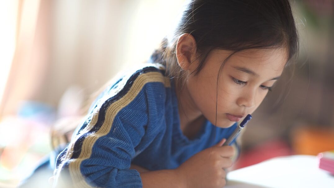 Young girl reading schoolwork