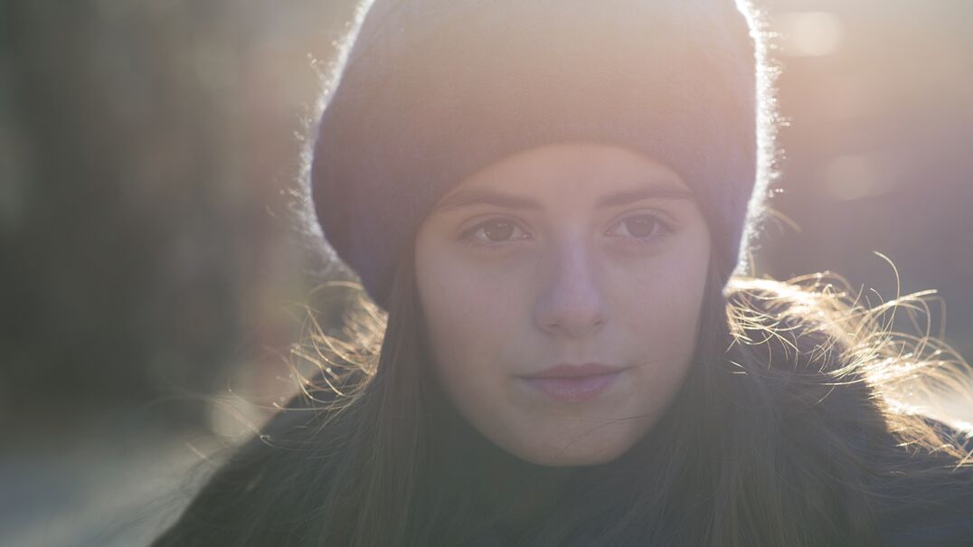 Teenage girl wearing beret standing outside