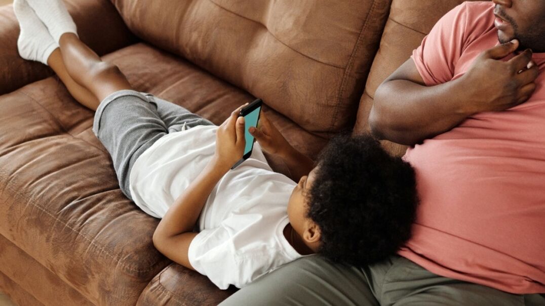 Father and son relaxing on a sofa