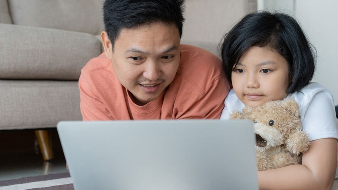 Father and daughter looking at laptop screen