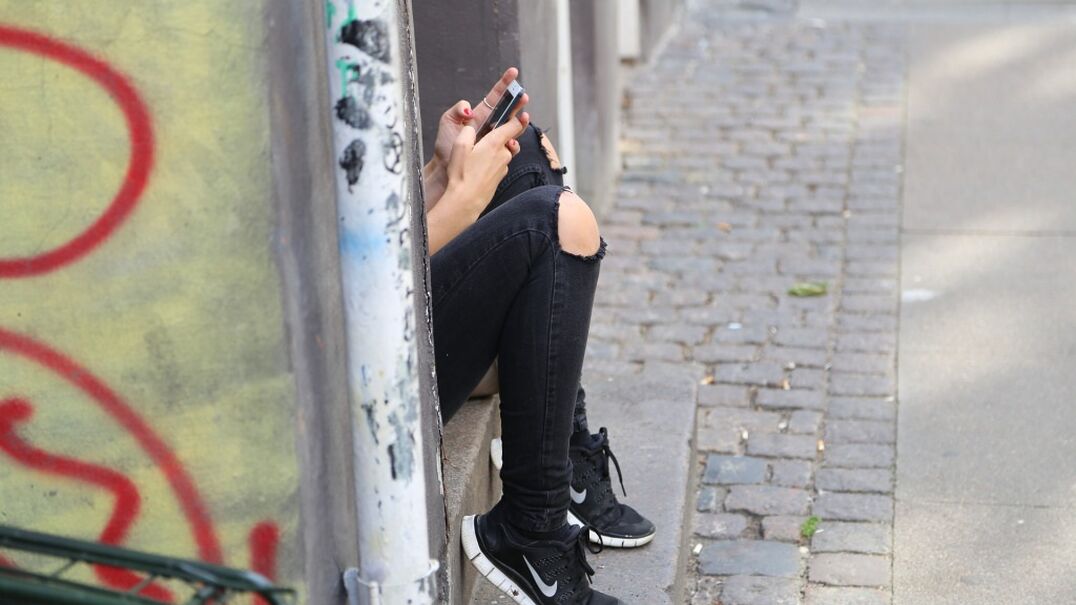 Girl sitting outside on phone