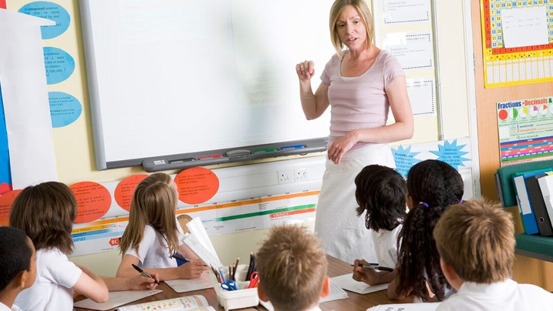 Teacher talking to students in a classroom