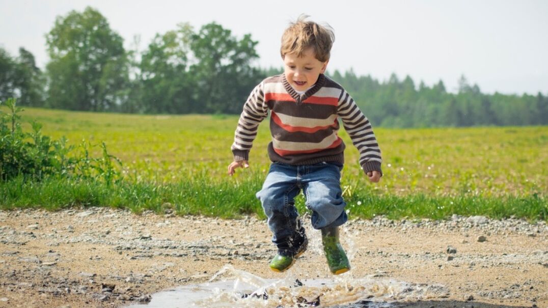 Kid jumping in puddle