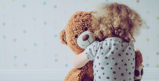 infant holding teddy bear