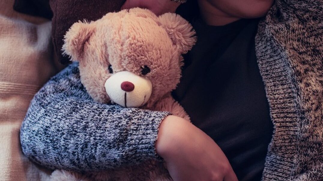 Child holding teddy bear