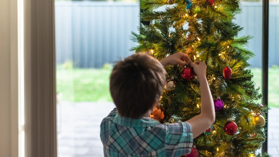 Young boy decorating a Christmas tree