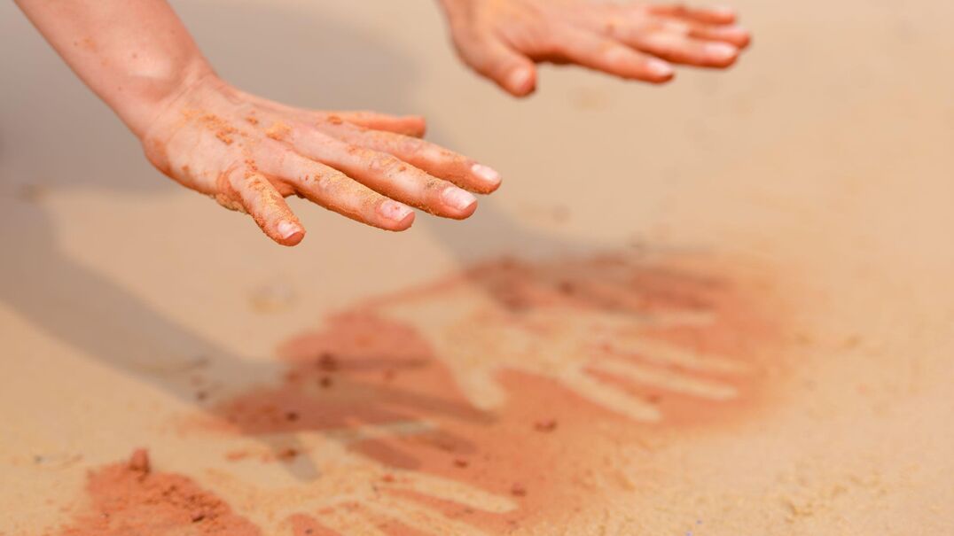 a persons handprint on sand
